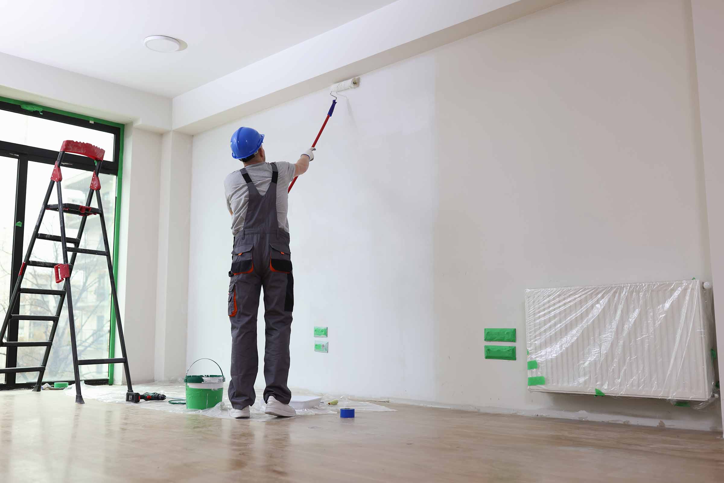 Professional Painter Paints Office Wall With Roller Brush.